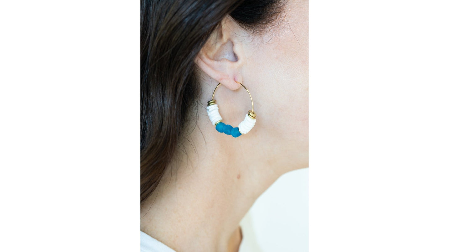 These stunning gold dangle hoop earrings are a My Sister's Cottage Design exclusive! The Sea Glass Heishi Earrings are handmade with recycled glass beads for a gorgeous coastal modern styling. The Chasing Waves Earrings are available in blush, sapphire, or seafoam variations and measure approximately 2". Expect some variation in beads due to recycled materials.